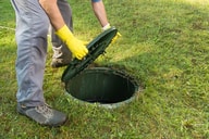 Lifting the cover off a septic tank in Phenix City, Al